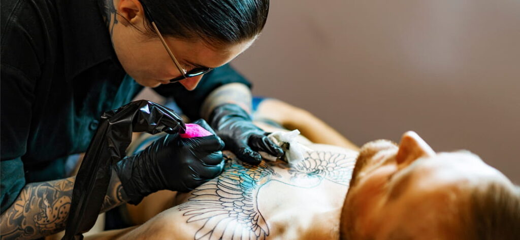 Tatuador tatuando peito do cliente